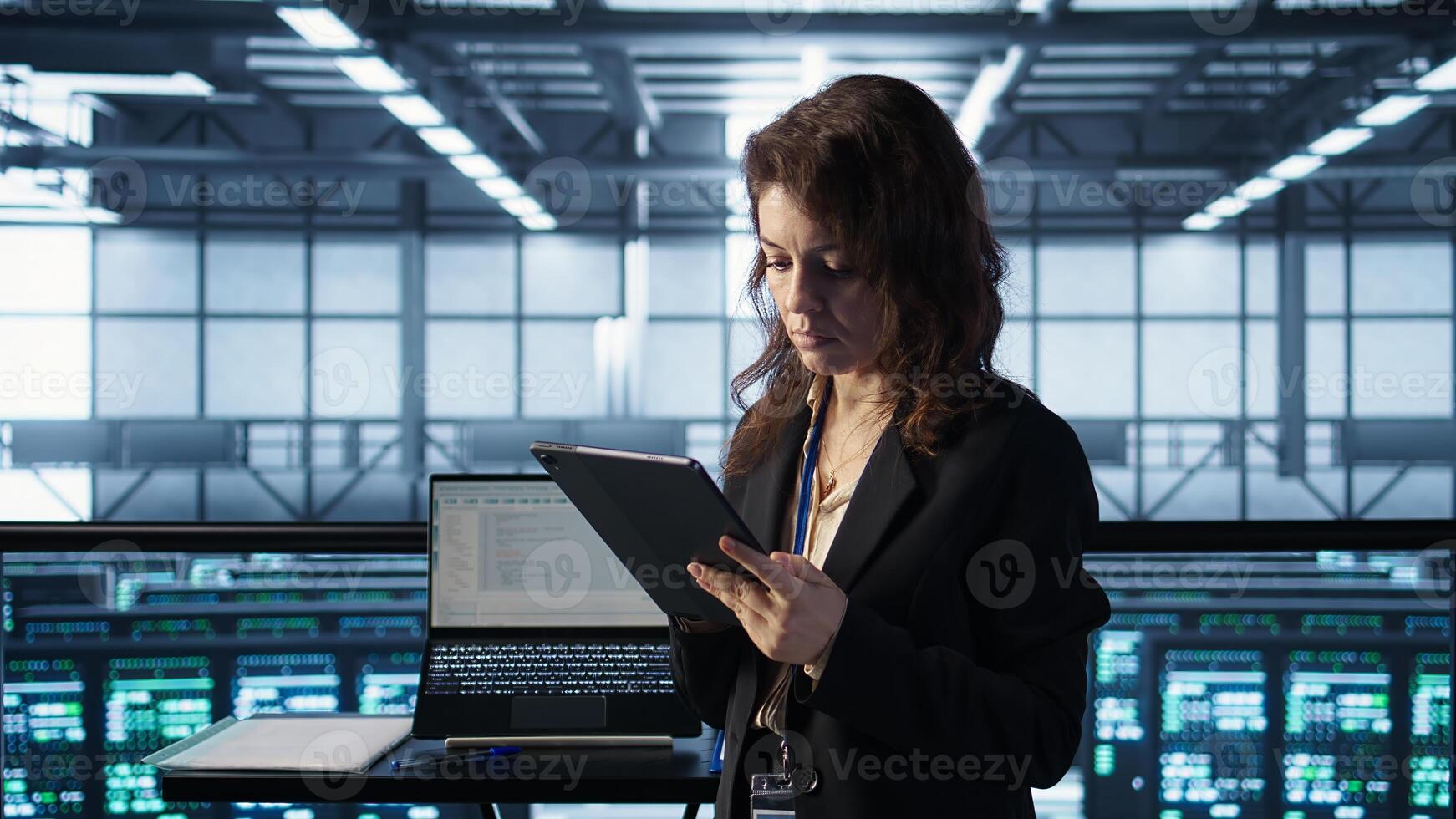 Technician in data center using AI tech on tablet, adjusting power management settings. Engineer in server room optimizes resource utilization using artificial intelligence, camera B photo