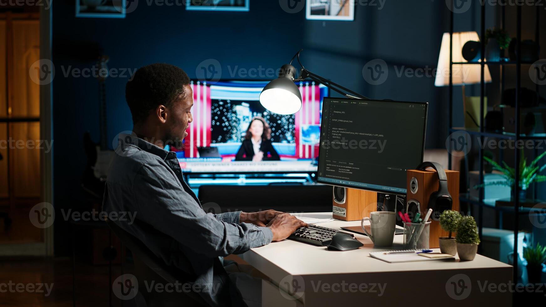 African american expert at desk using pc for programming and data analysis. Young networking expert working from home, manages information technology and data center. Camera B. photo