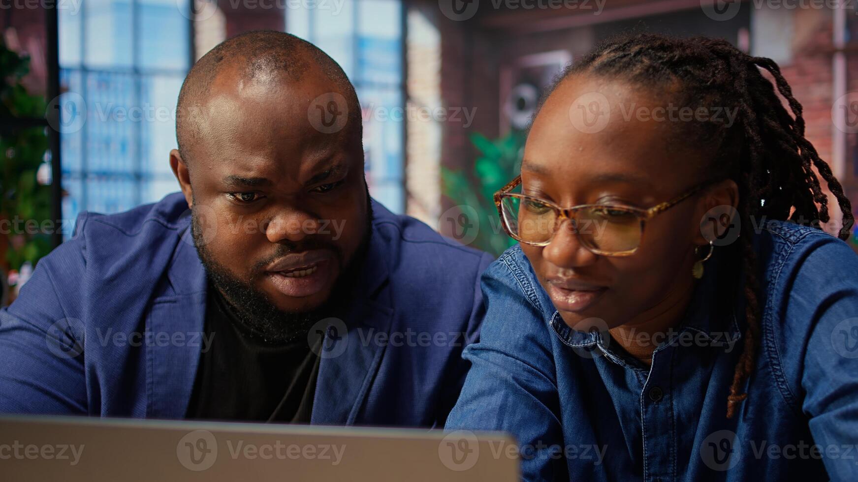 Black man and woman creating report with online data from archived files, improving skills and achieving career independence. Remote workers solving daily tasks. Camera A. photo