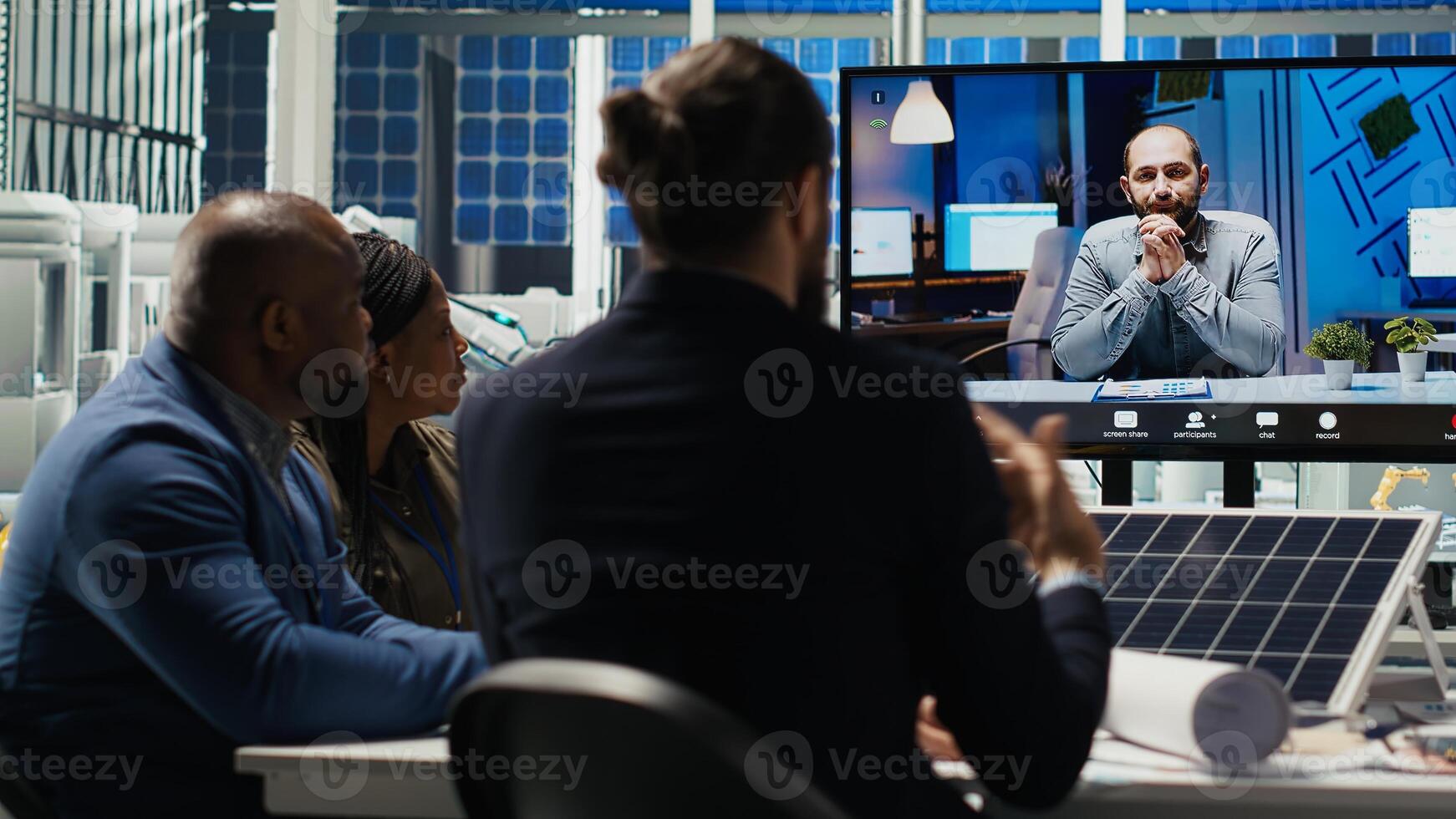 Photovoltaics researchers doing videocall to optimize energy production. Solar panels specialists developing innovative manufacturing tech during remote teleconference, camera B photo
