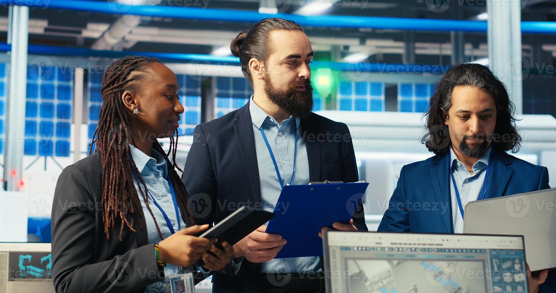 Portrait of cheerful inspectors in photovoltaics factory diagnosing malfunctioning systems. Happy supervisors inspecting solar panels manufacturing plant to reducing downtime, camera B photo