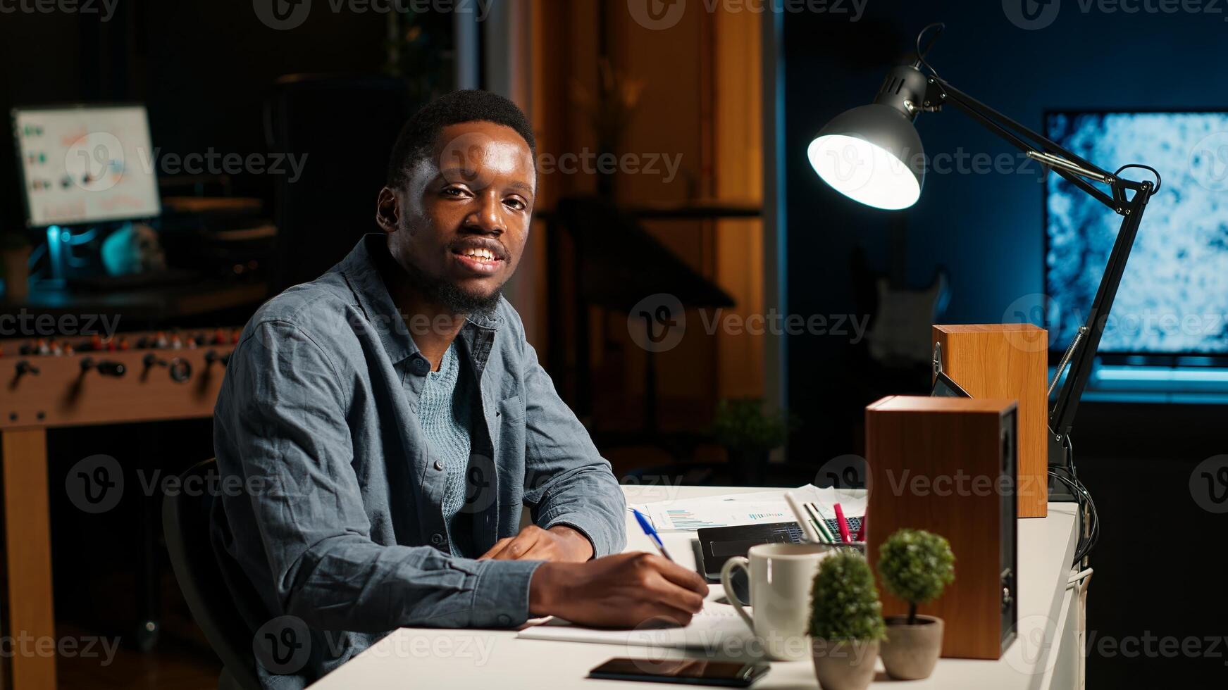 POV waving from personal office, black man participates in online call meeting. Young conference speaker addressing business topics with attendees, web teleconference chat. Camera B. photo