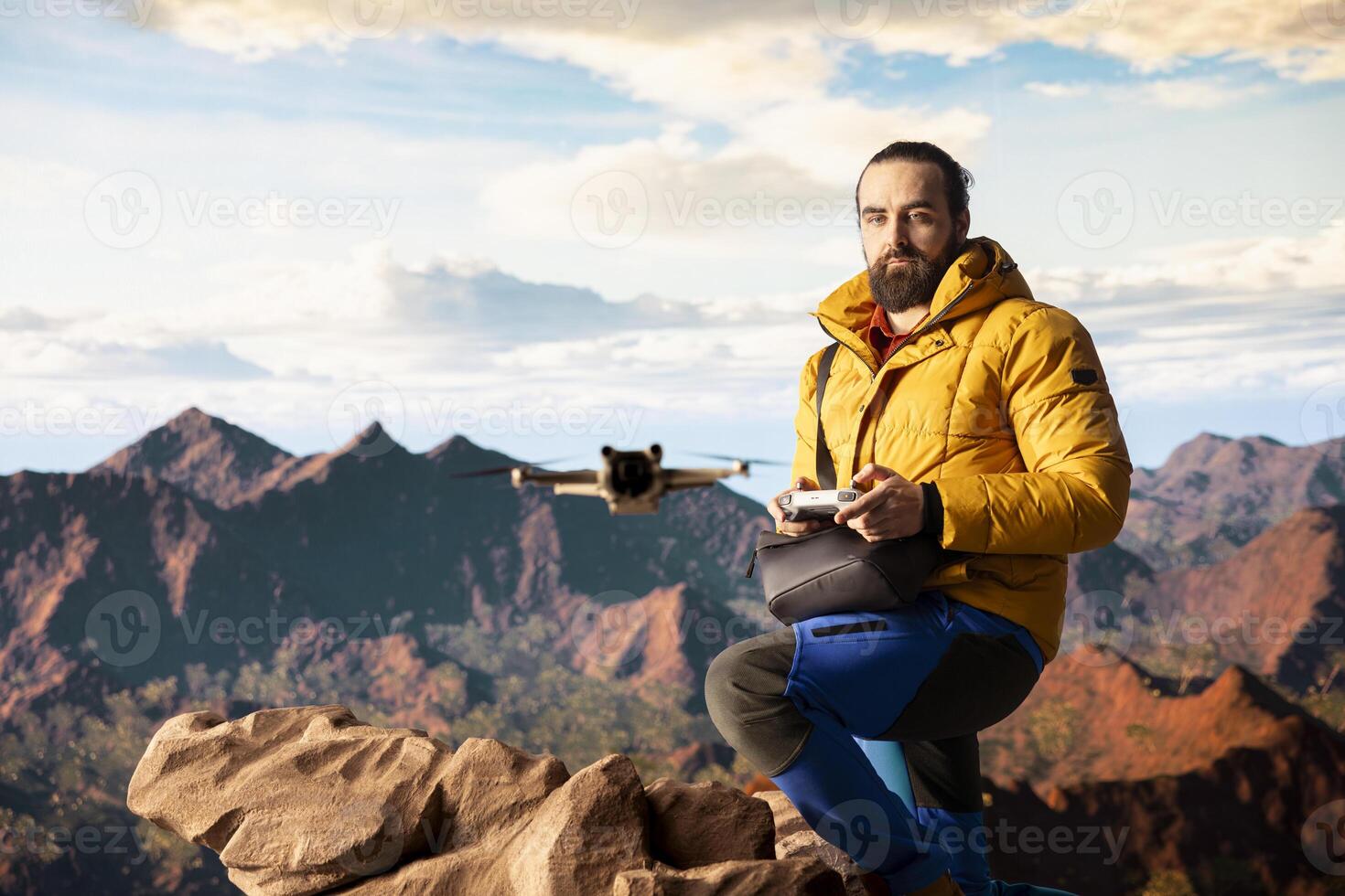 Male influencer shares hiking journey through vlog with drone, recording high quality aerial view content with remote control. Young hiker content creator filming scenery. photo