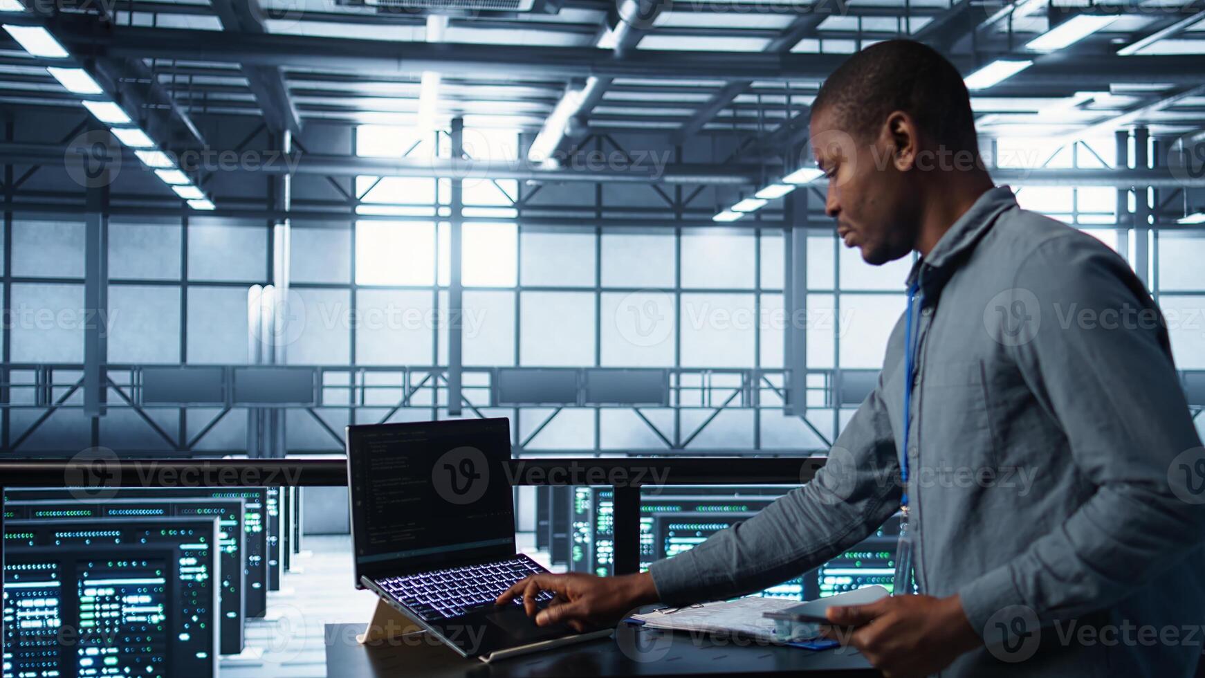Technician with laptop and tablet integrating AI driven automation tools. Server room worker using artificial intelligence on devices, ensuring continuous uptime, camera B photo