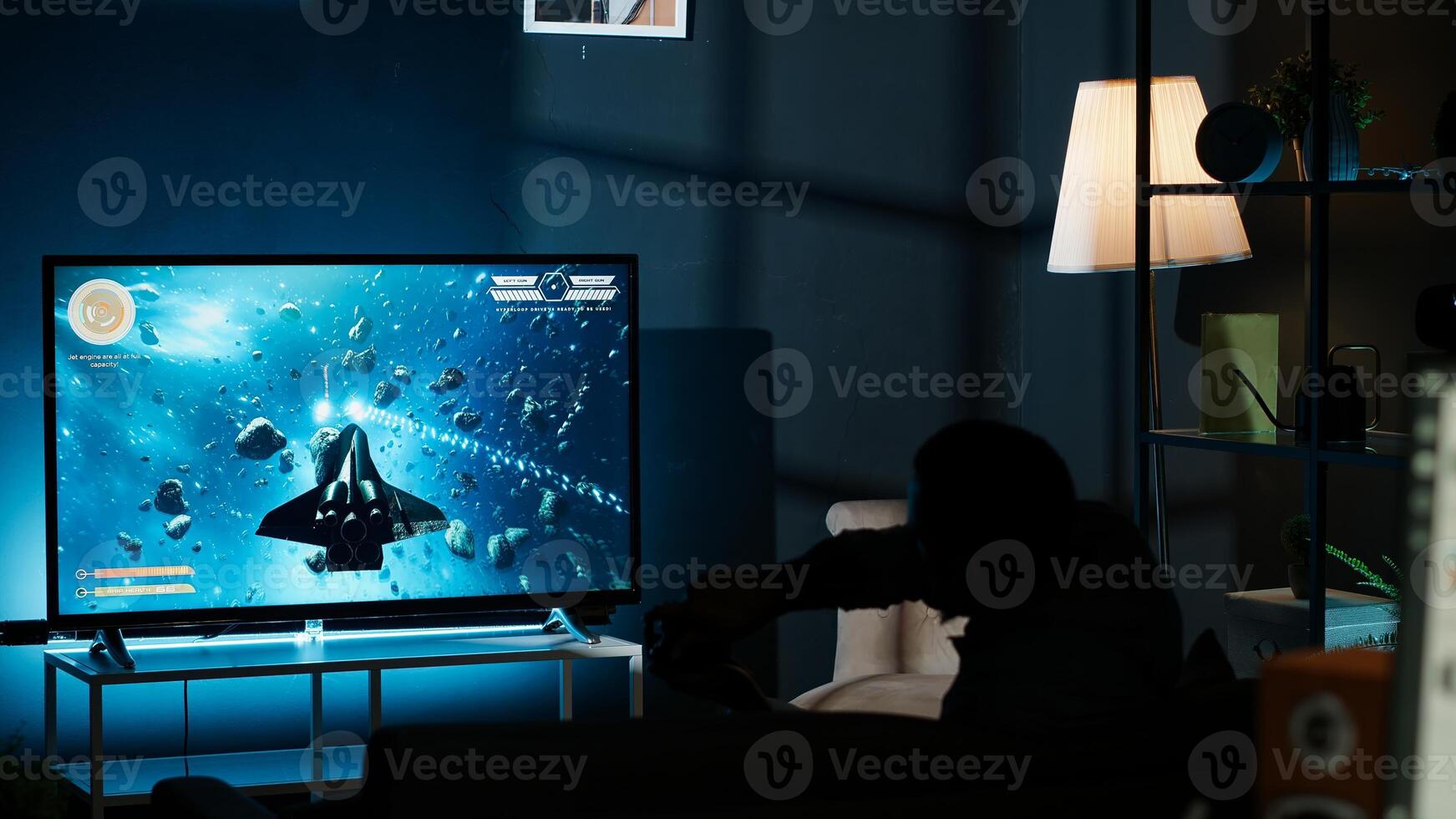 Guy playing online tournament and winning round, plugging console into television and having fun with successful competition at night. First person shooter. Camera B. photo