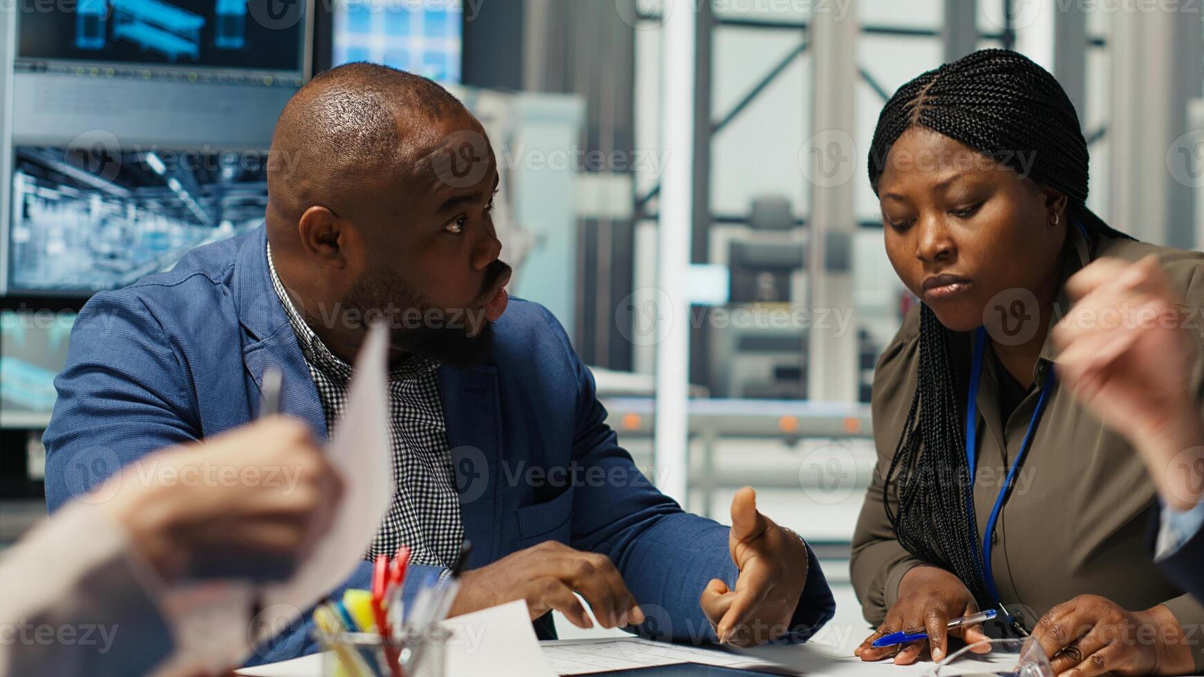 Engineering team looking at assembly lines designs, working to increase energy output. Photovoltaics experts brainstorming innovative solar cells prototypes, looking over schematics, camera B photo