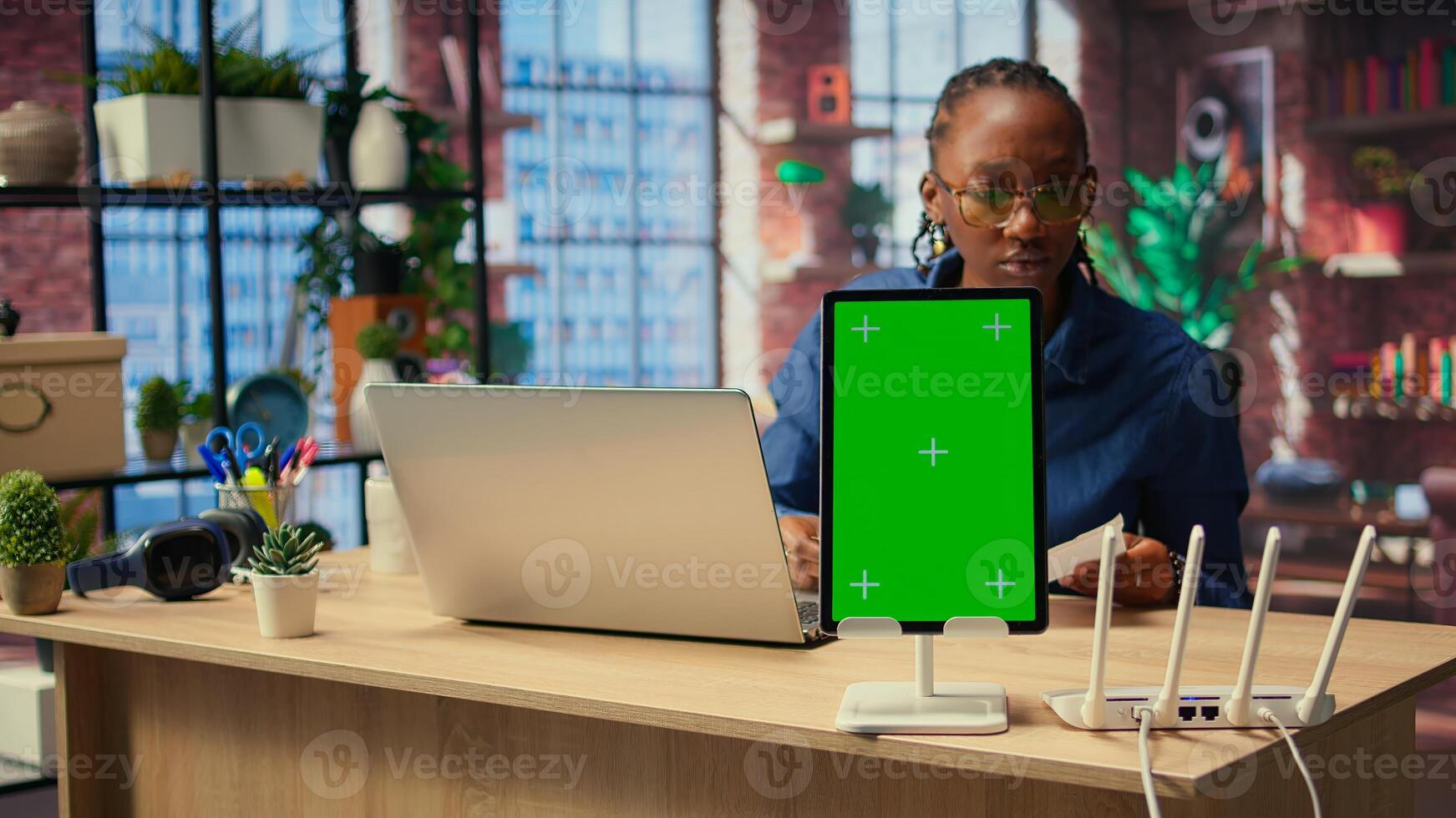 Black girl tries to fix Wi Fi error by rebooting router next to isolated screen, troubleshooting signal loss problems to solve technical issues. Testing different configurations. Camera A. photo