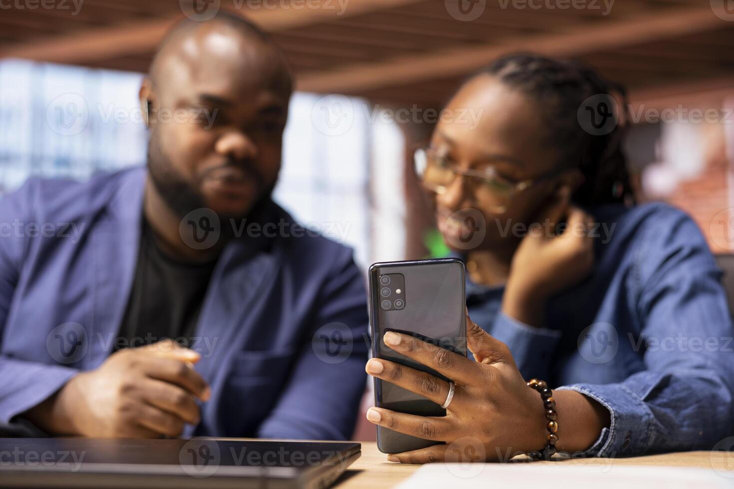 Black couple coworkers joining their colleagues on a call connection, enjoying the benefits of a remote job through online communication from their home. Virtual briefing meeting. photo