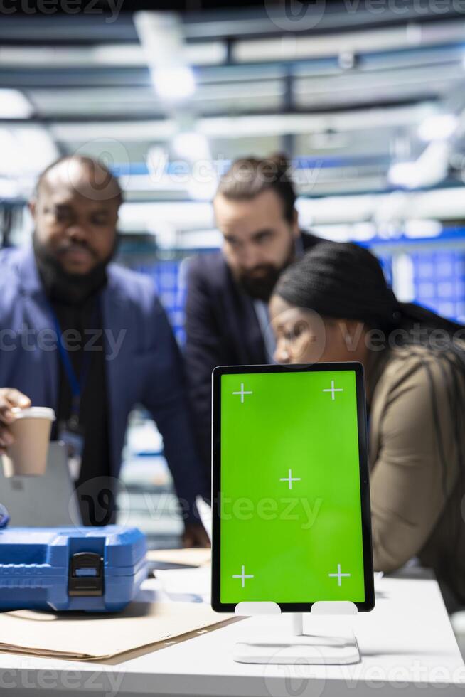 Solar panel inspection group review data on pc next to green screen, finding errors during a process audit and helping optimize renewable energy operations. Photovoltaics factory. photo