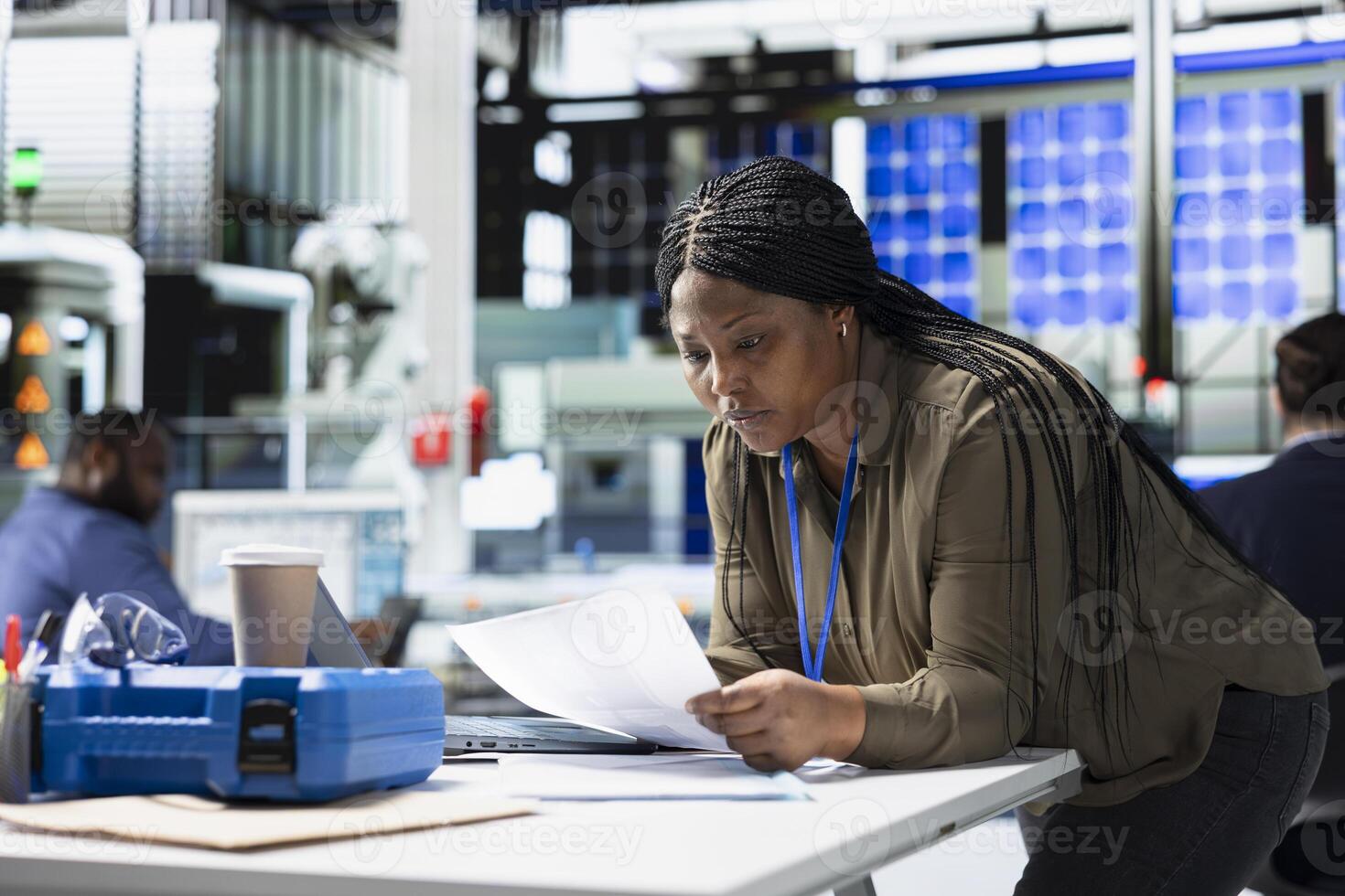 Woman master engineer reviewing production line data on papers, manages factory activity in a solar panel plant to ensure effective quality control and commitment to renewable energy tech. photo