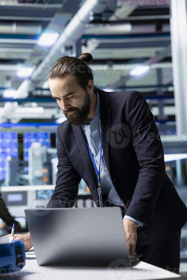 General director in formal suit conducting inspection in a solar panel plant, symbolizing modern infrastructure and leadership in green energy industry. Production planning and technology. photo