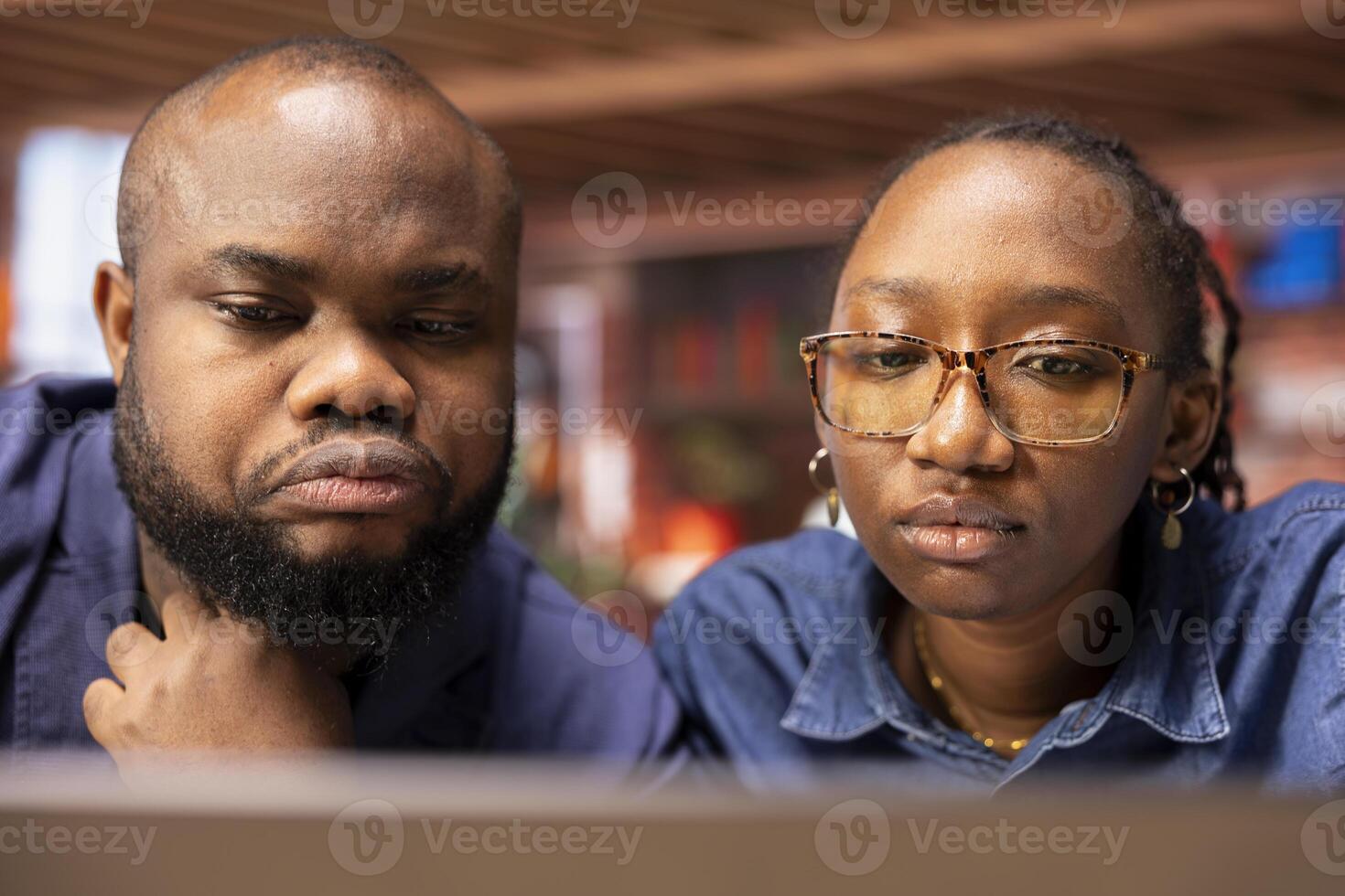 African American couple works from home collaborating on a freelance project in their modern apartment, using a laptop to plan strategies, boost productivity, and achieve business success. photo