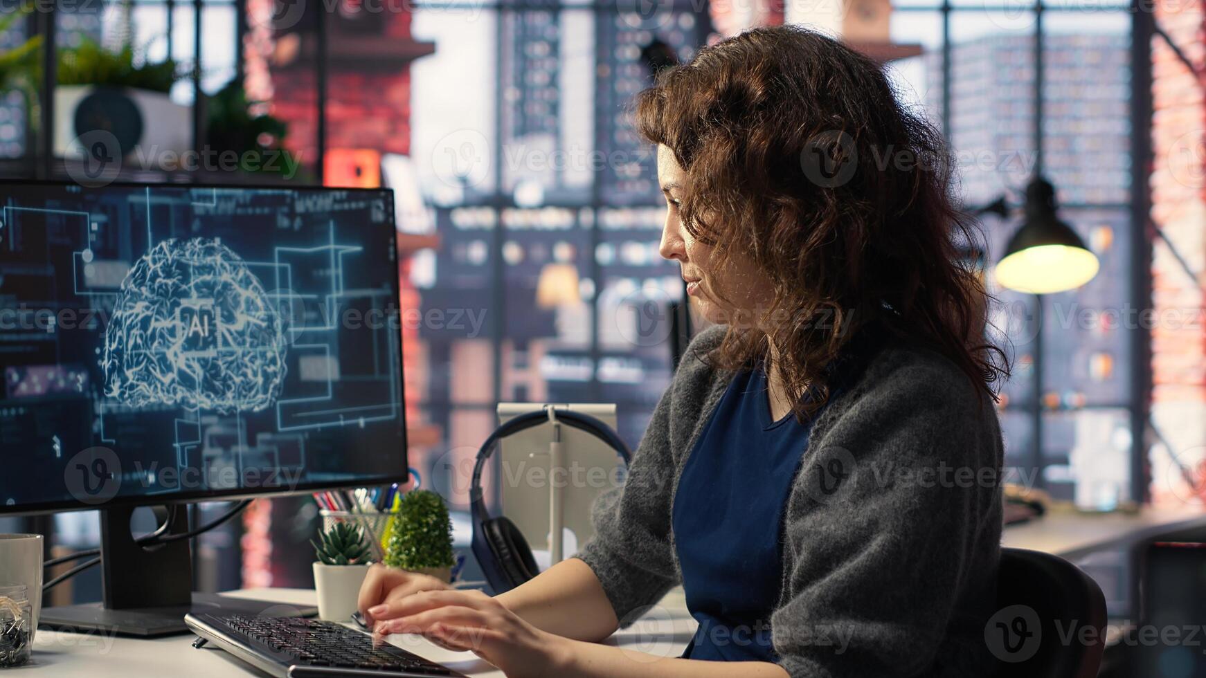 Female system admin doing maintenance on AI brain pc systems, sitting at office desk. Girl works as a software developer with cybernetics and algorithms for machine learning. Camera B. photo
