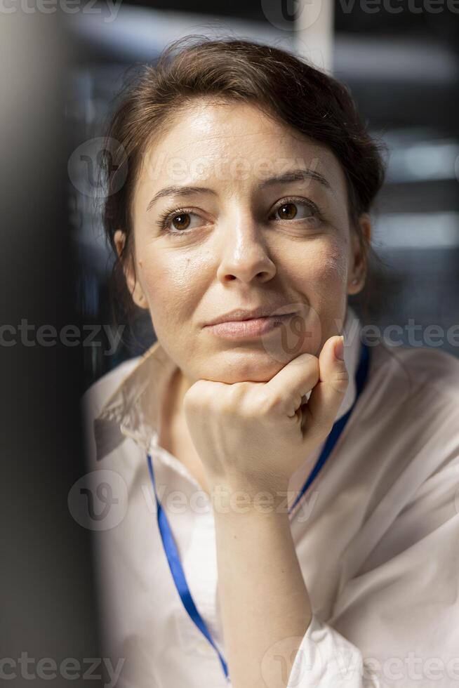 Close up of smiling data center engineer inspecting gear, doing maintenance tasks, checking performance diagnostics. Upbeat server farm IT expert conducts system checks to ensure operational stability photo