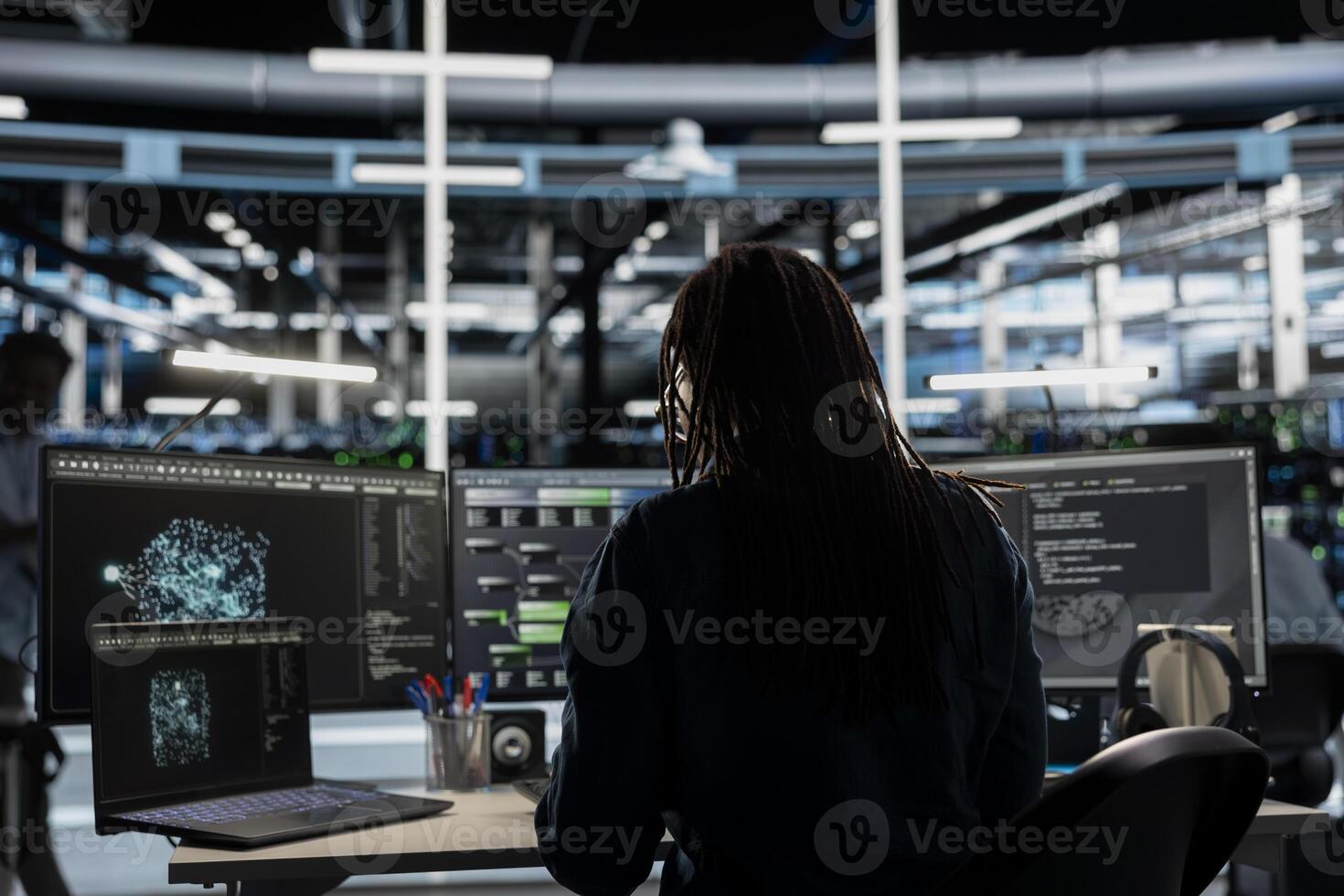 Data center admin looks at AI visualization dashboard on laptop to pinpoint equipment performance issues. Server farm specialist looks at data analysis graph on notebook to reduce hardware failures photo
