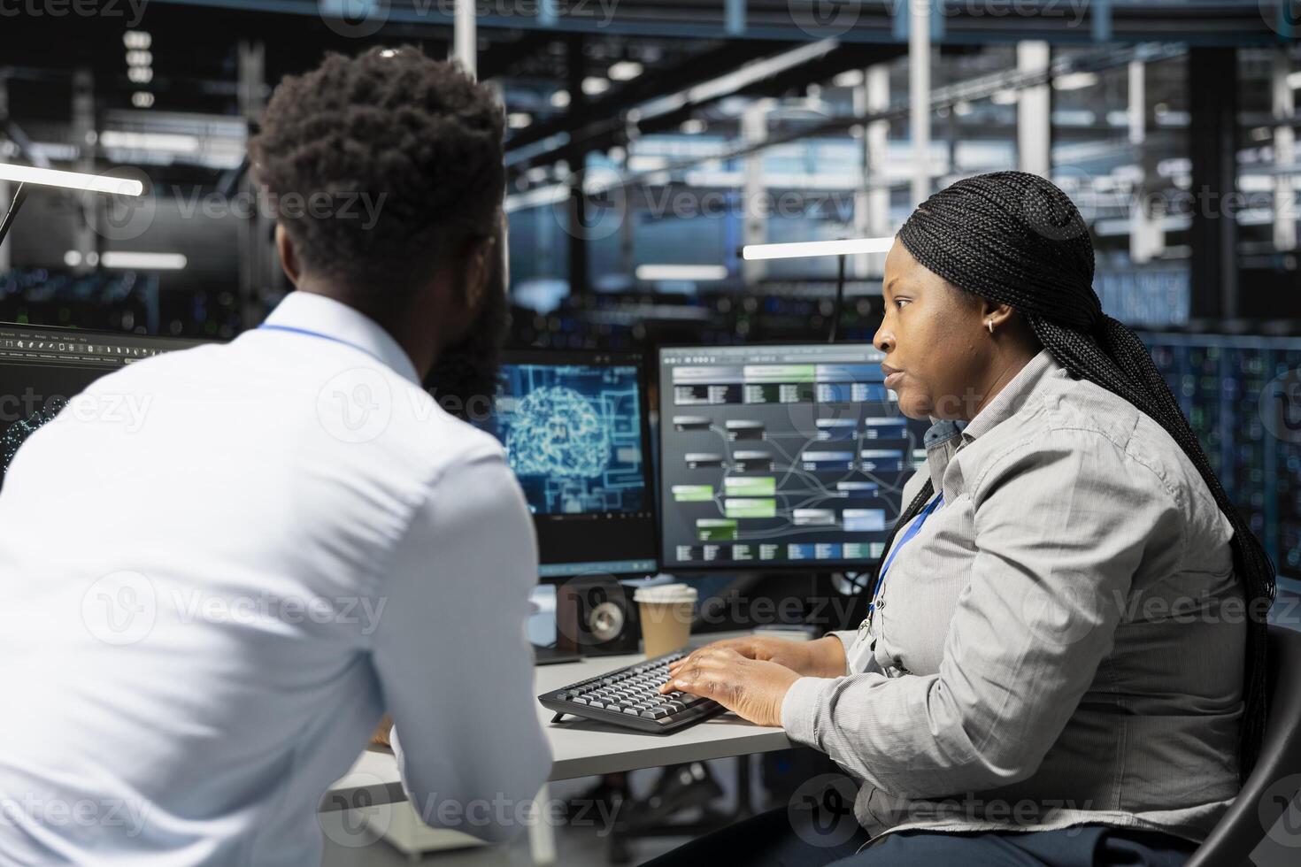 Data center engineering team using artificial intelligence neural networks technology. Professional and coworker in server room using AI programming language to configure specialized hardware photo