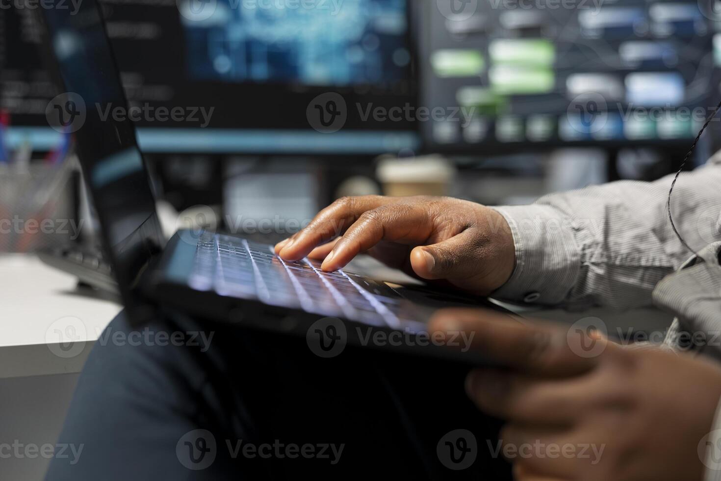 Close up of data center technician using artificial intelligence computerized model on laptop. Server room employee typing on notebook keyboard, using machine learning AI algorithms photo