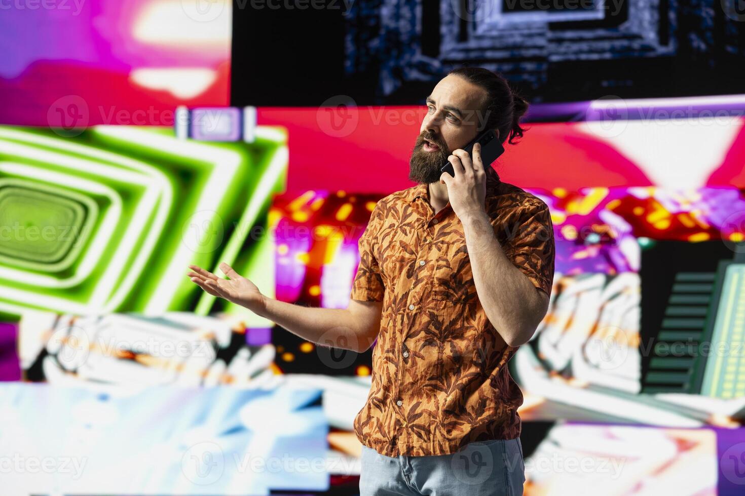 Stylish vlogger and DJ answers a phone call under vibrant neon lights, nightlife vibe with music culture, visuals and urban ambiance for social media or digital streaming. Cool creative guy. photo