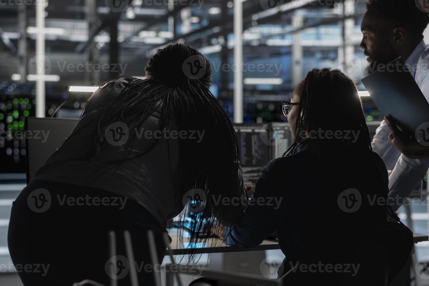 Server farm engineering team implementing and managing data backup solutions. Teamworking data center colleagues identifying and resolving technical errors, ensuring efficient recovery photo