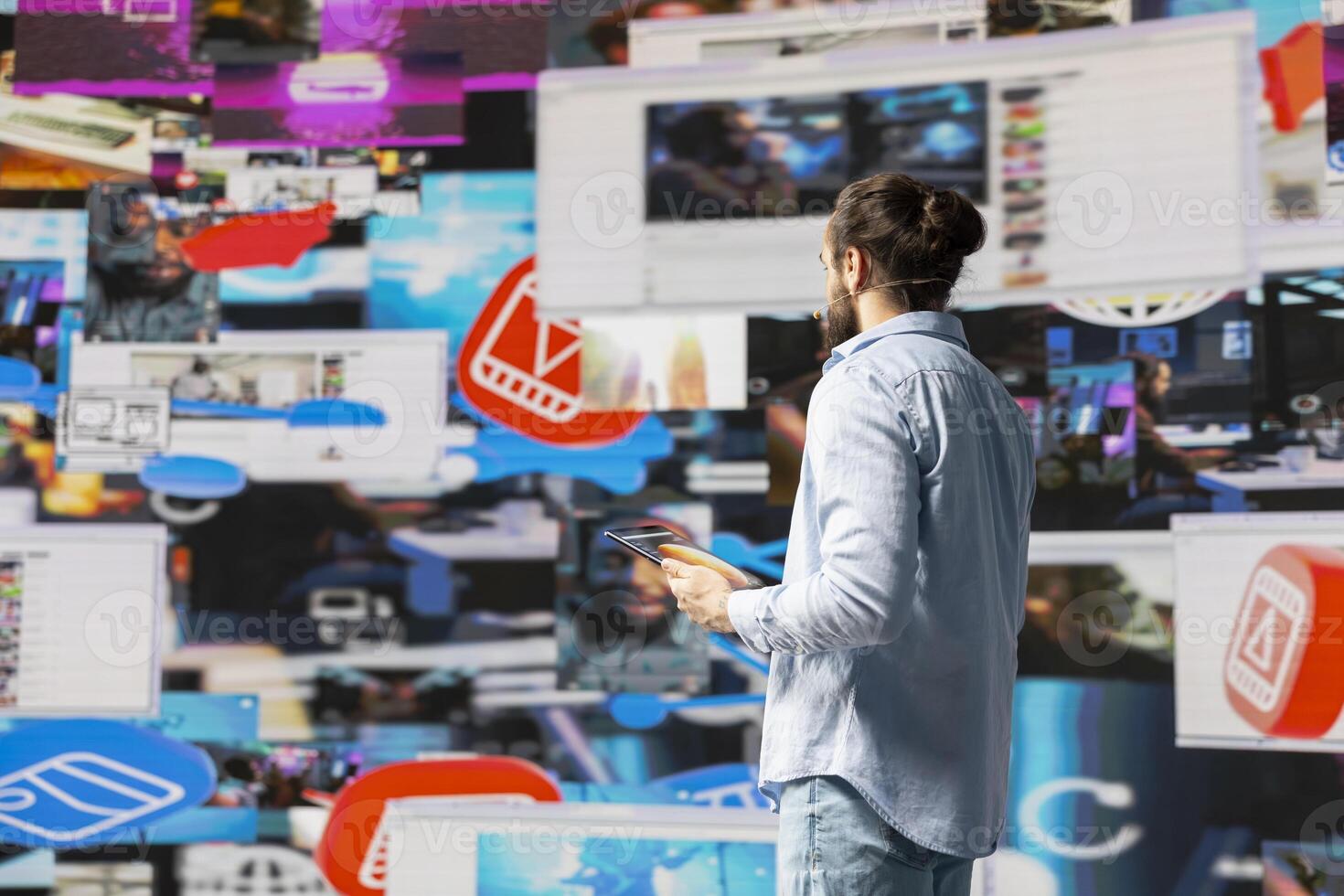 With a hands free microphone, male influencer hosting a live discussion presentation offers insight for visibility. Male speaker gives advice with the audience to boost online engagement. photo