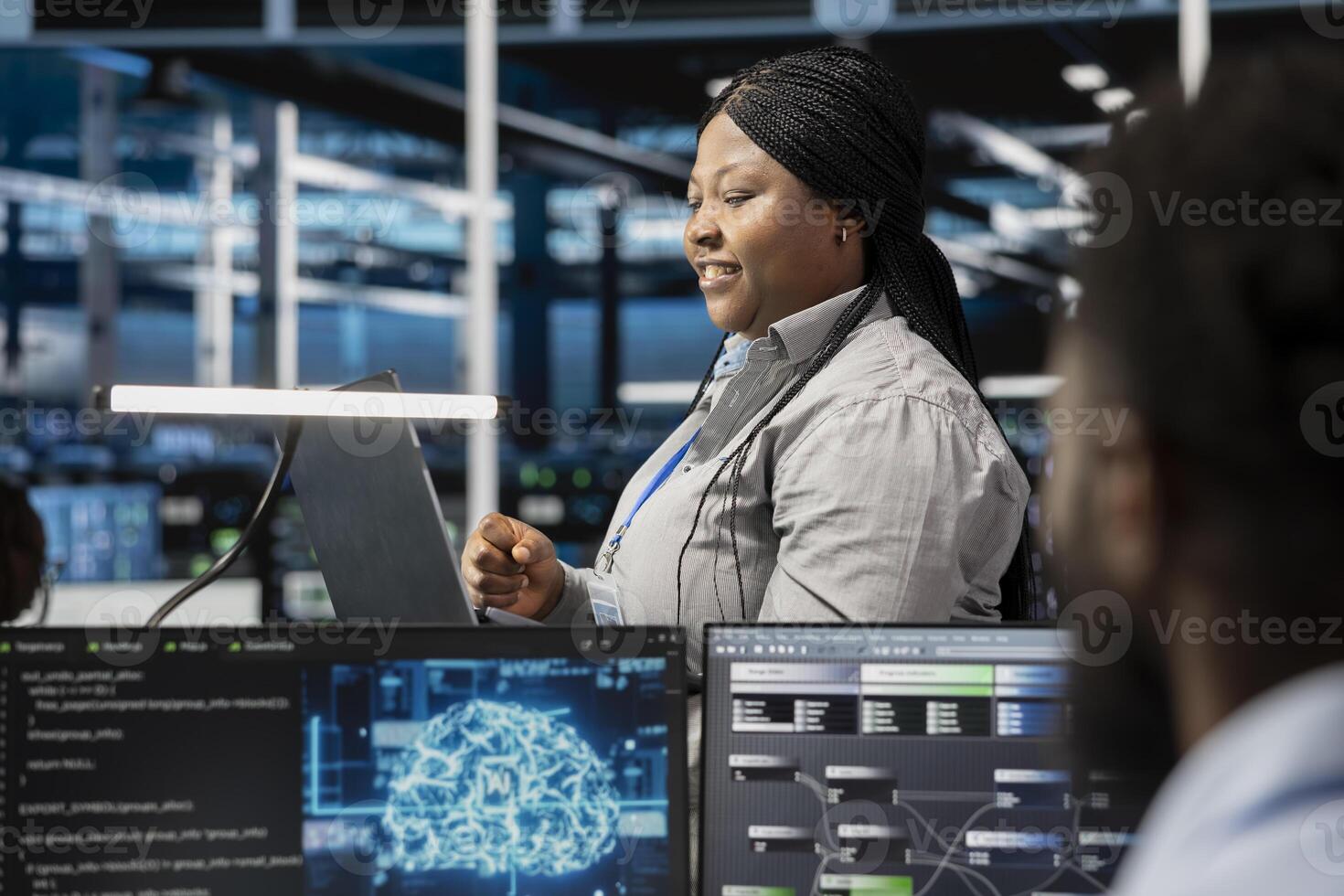 Smiling server room developer using artificial intelligence to enhance operational efficiency and reduce downtime. Happy employee designs and implements AI driven solutions for data center equipment photo