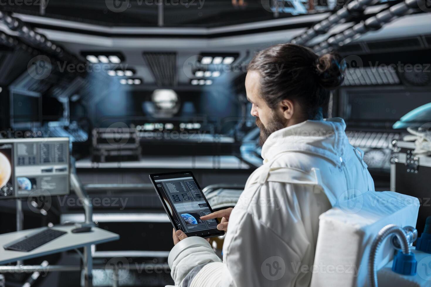 Scientist in spaceship analyzing mission logs on device while carrying out research aboard starship. Astronaut researcher wearing cosmonaut gear looking at tablet interface showing orbital path photo