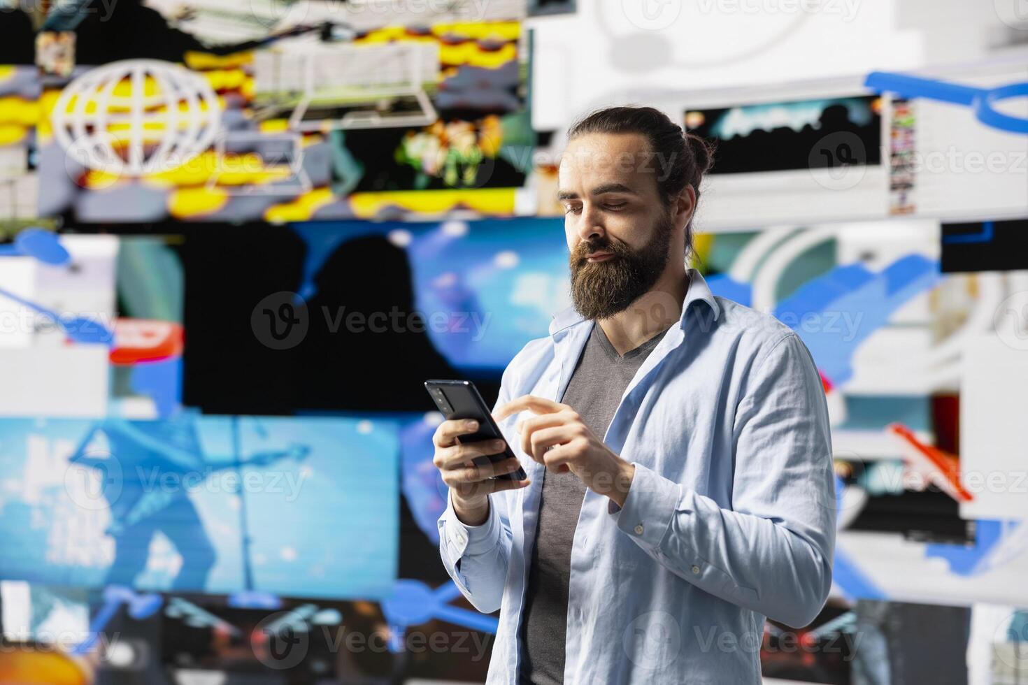 Young modern person focused on his smartphone app and scrolling on social pages, texting his friends and creating quality content for global reach. Trend setter cool guy on web connection. photo