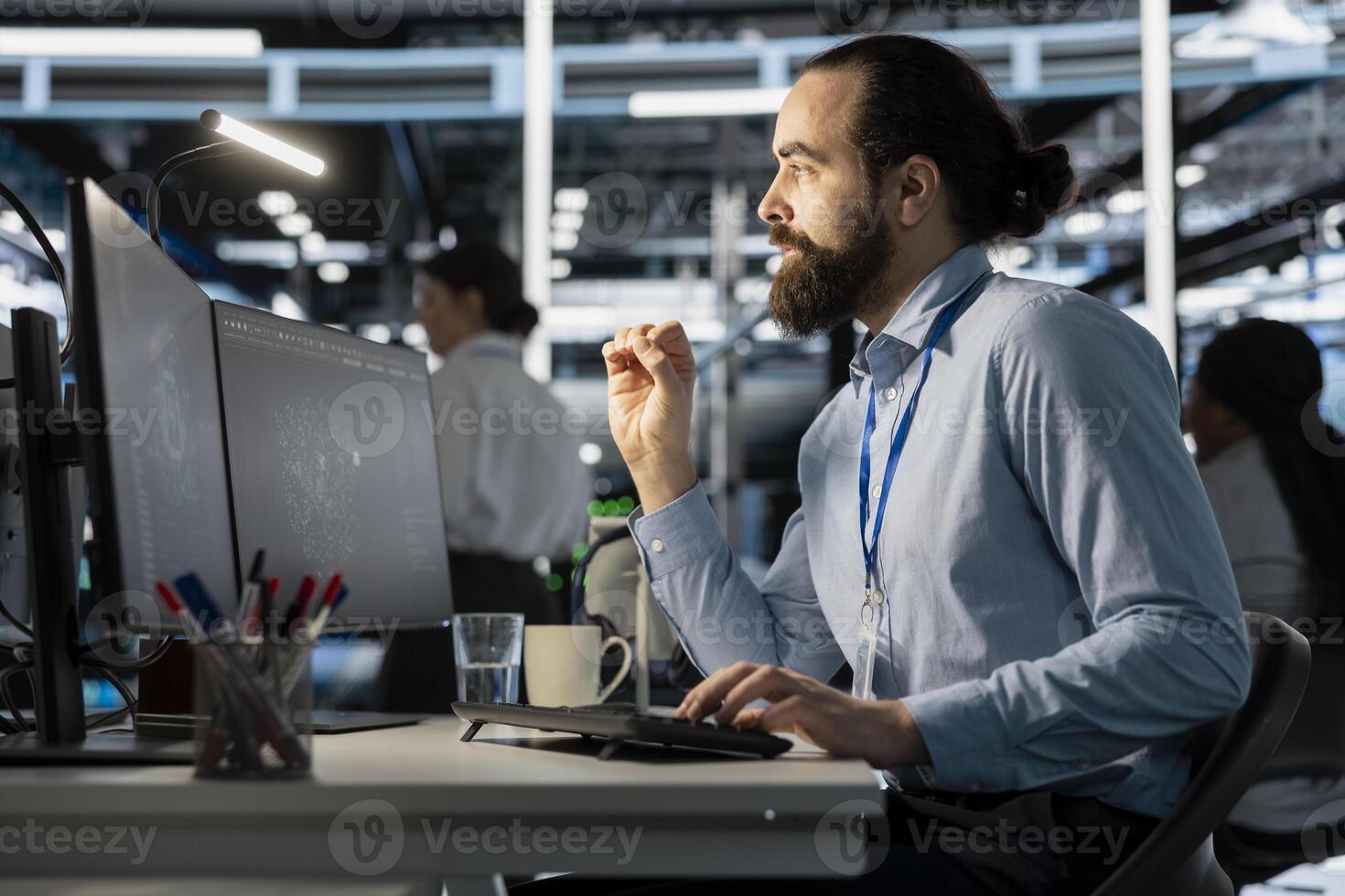 Programmer in data center using computer, doing software updates, verifying neural network parameters. Server room worker using PC to inspect configurations, ensuring optimal application performance photo
