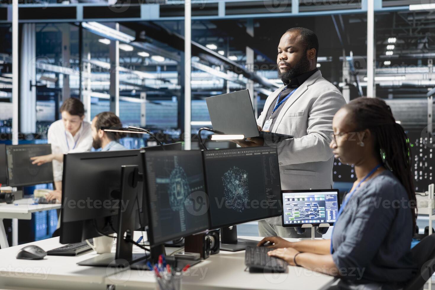 Data center IT experts using artificial intelligence neural networks technology. African american server farm facility software developers using AI programming language on computer to update hardware photo