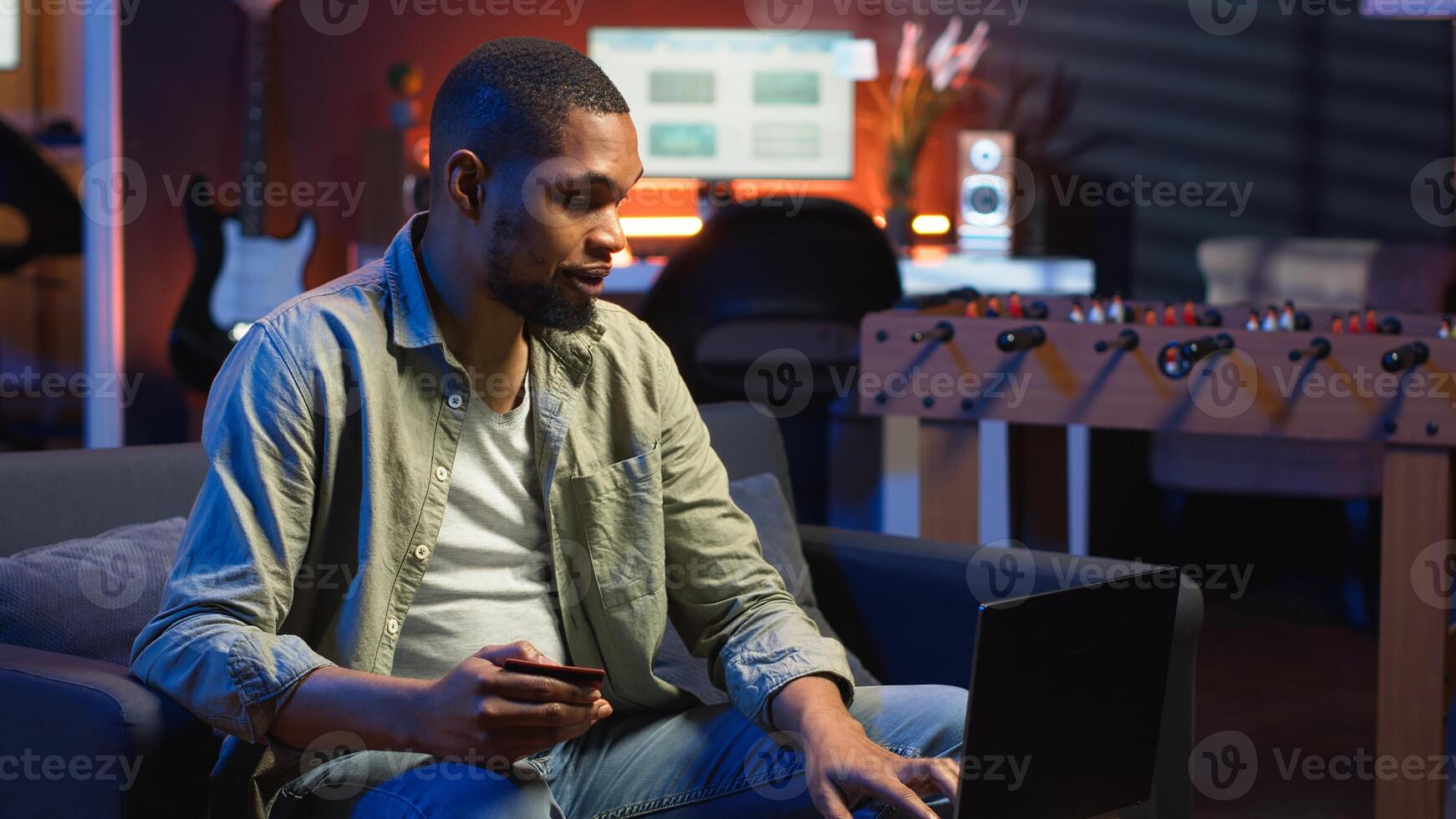 Young guy managing online banking and payments with the credit card, entering digits on website to confirm and oversee money transfer. Casual woman at home makes transactions. Camera B. photo