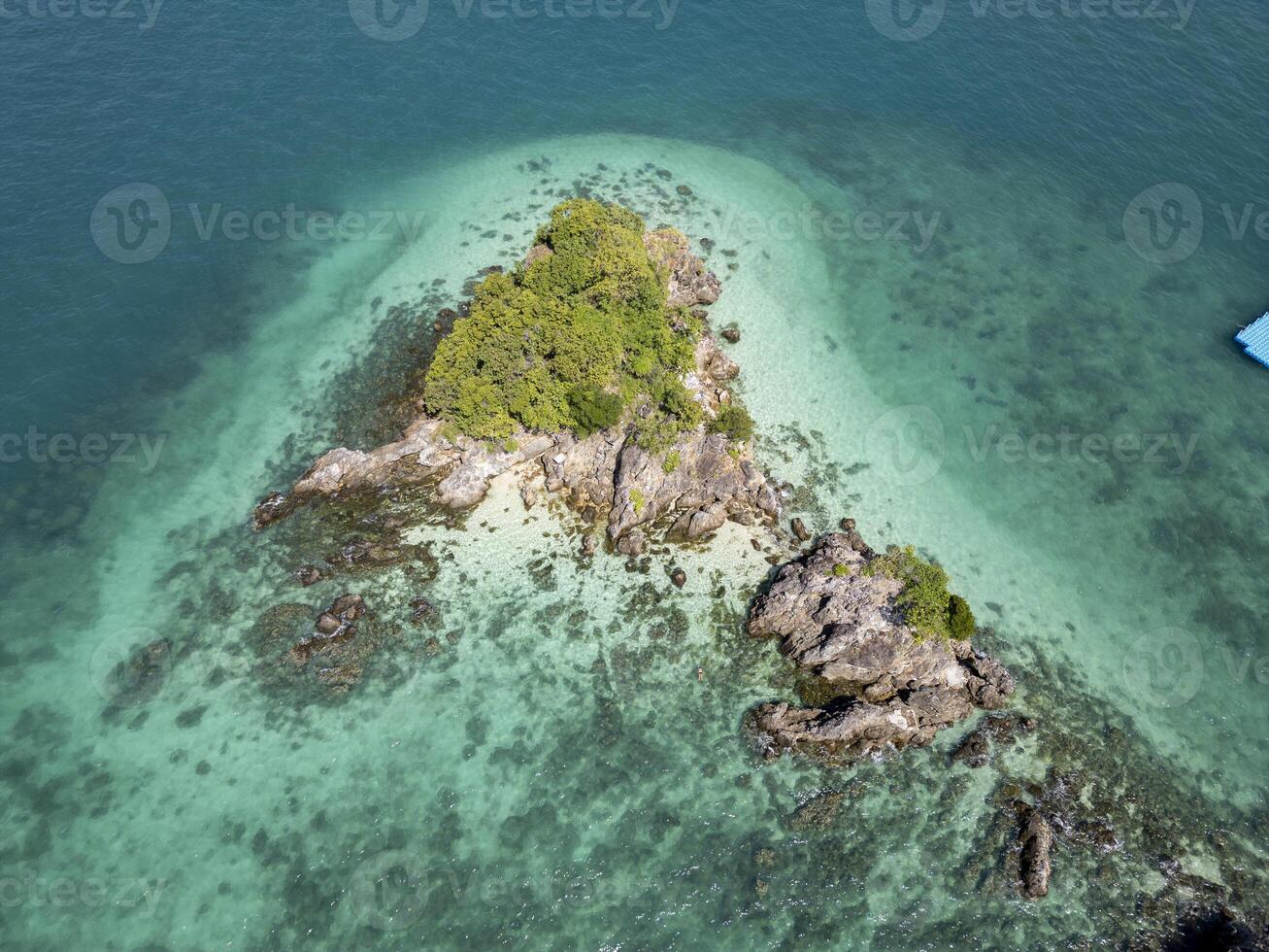 Aerial view of tropical rocky shoreline with lush island scenery, beautiful seaside landscape featuring a tranquil rocky beach with harbor and clear blue waters. Exotic shoreline scenery. photo
