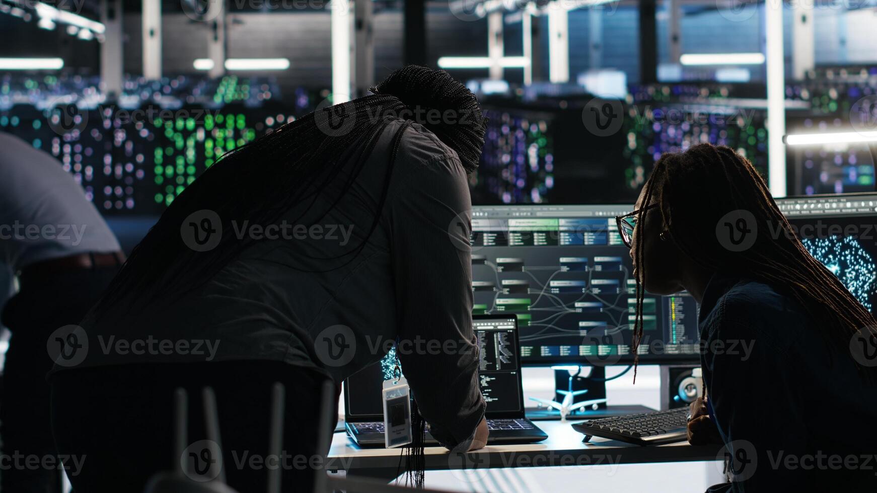 Data center colleagues using node tree program to identify equipment performance issues. Server hub engineering team coworkers review data analysis graph to minimize failures, camera B photo