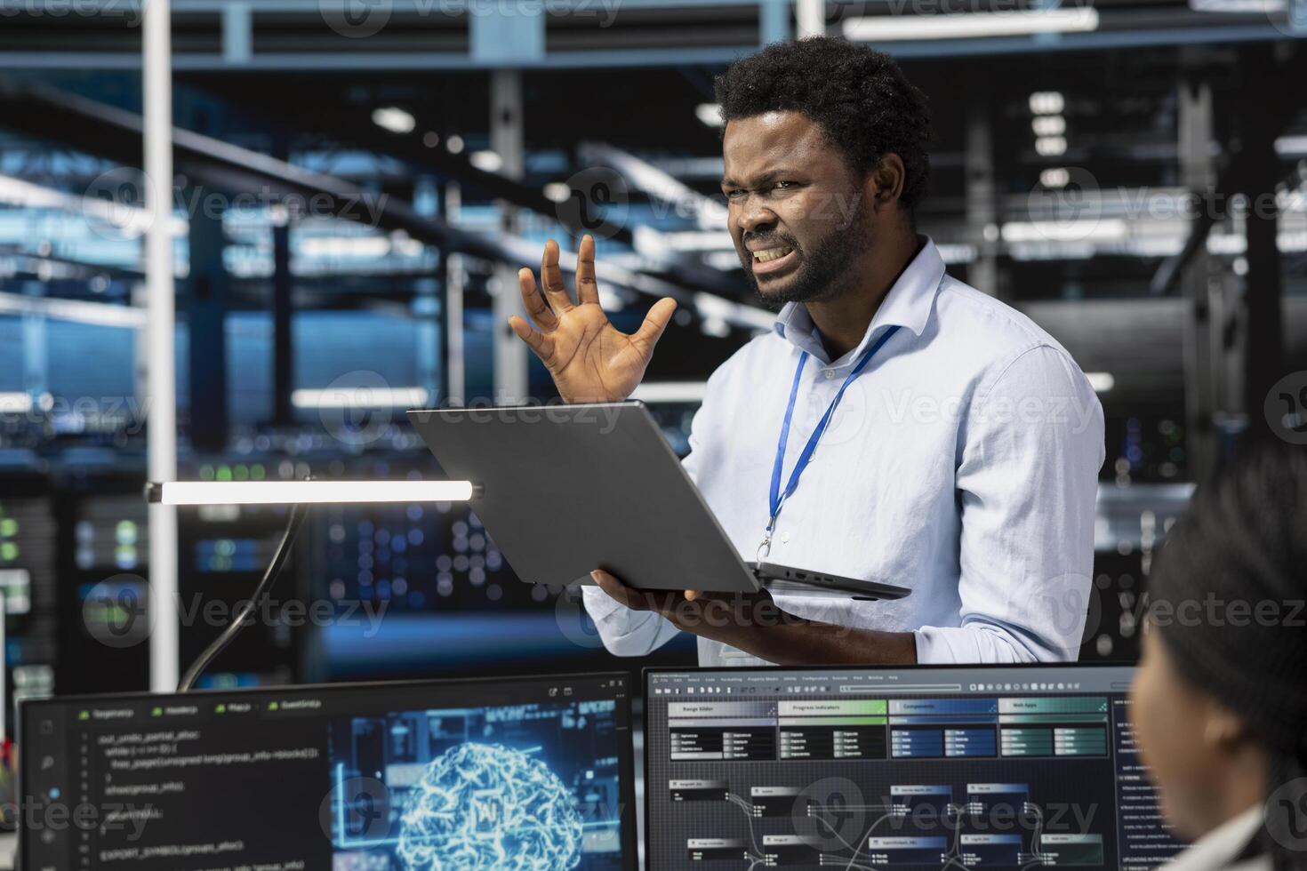 Frustrated technician angered by glitching data center equipment needed to run artificial intelligence and machine learning. Annoyed server room worker irked by errors while using AI tools photo