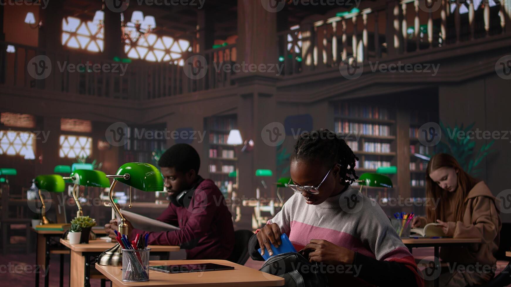 Black girl focuses on exam preparations in campus library, takes notes on laptop from reference books in peaceful study setting. Girl uses general database materials. Camera A. photo