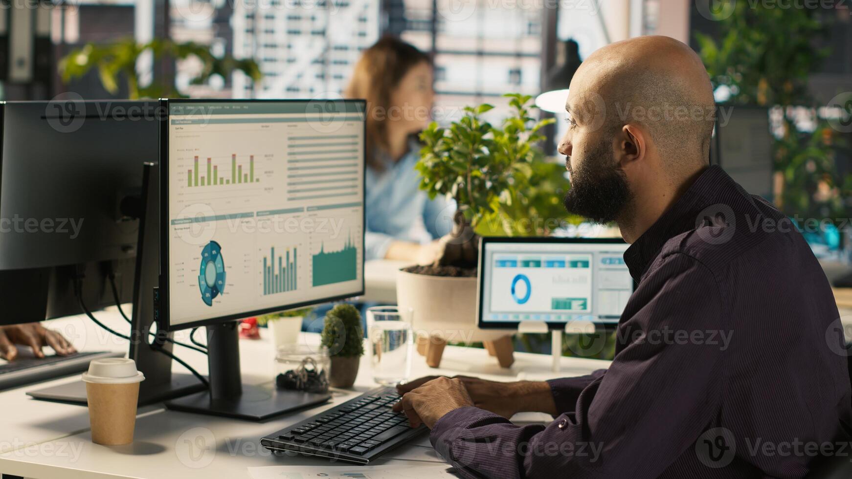 Employee editing documents on computer at office desk, updating reports and files. Worker analyzing data charts on desktop screen, interpreting statistical information, camera A photo
