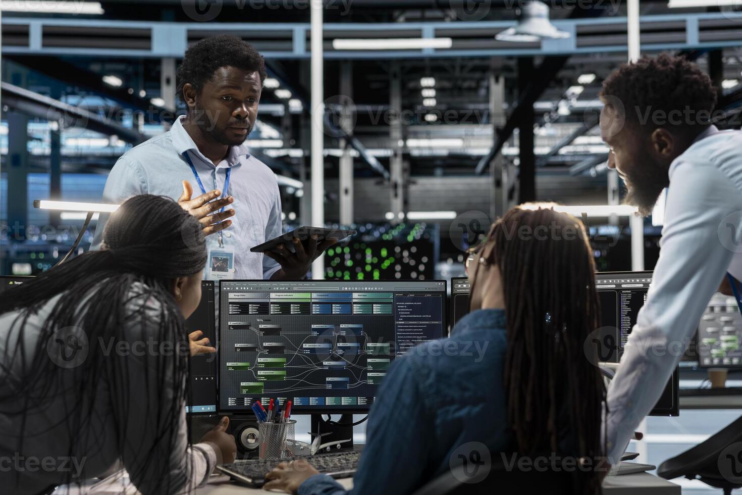 Engineers doing brainstorming, programming in server farm housing infrastructure storing datasets. Teamworking colleagues run code on PC to repair data center racks doing computational operations photo