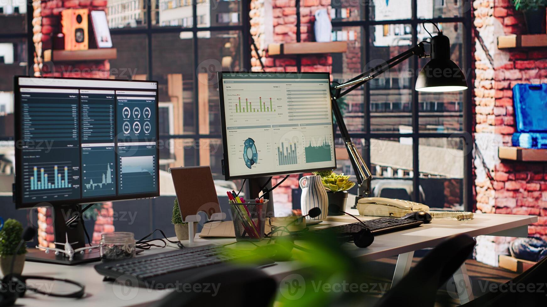 Computer monitors on desk showing data analytics dashboards and performance charts. PC screens in company workspace displaying financial metrics and productivity data photo