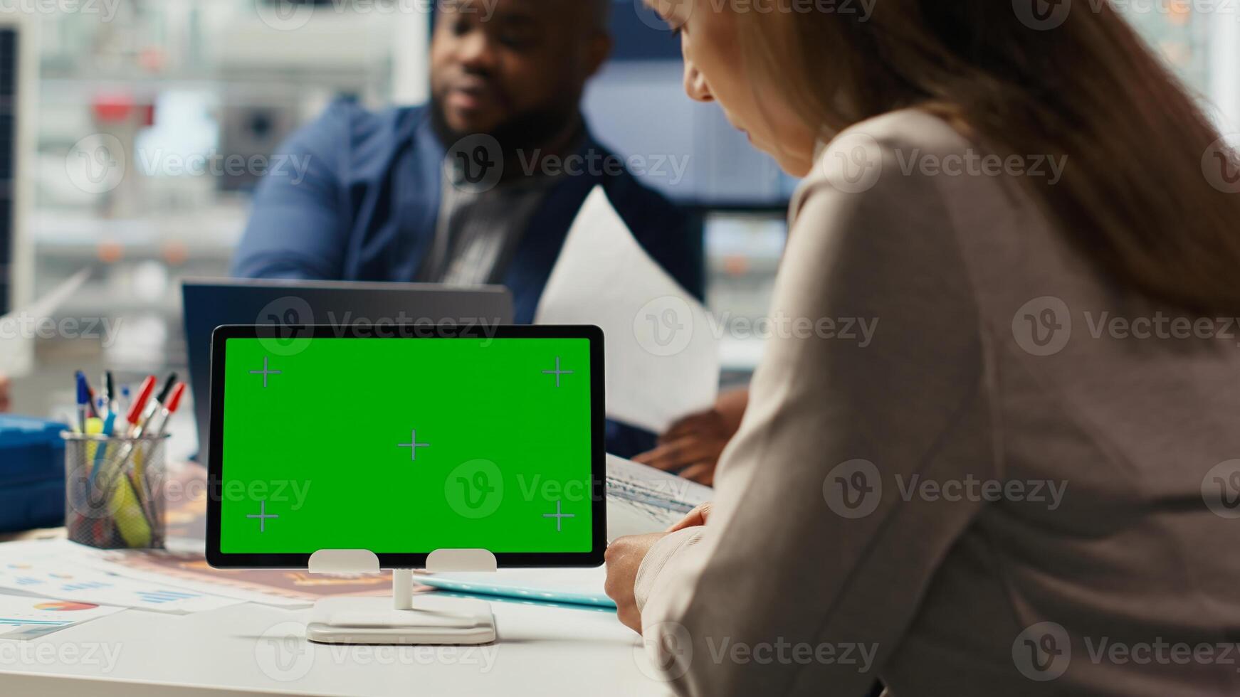 Shareholders in photovoltaics plant analyzing market trends on isolated screen tablet to determine investment strategy. Managers look at data on mockup device, expanding factory production, camera B photo
