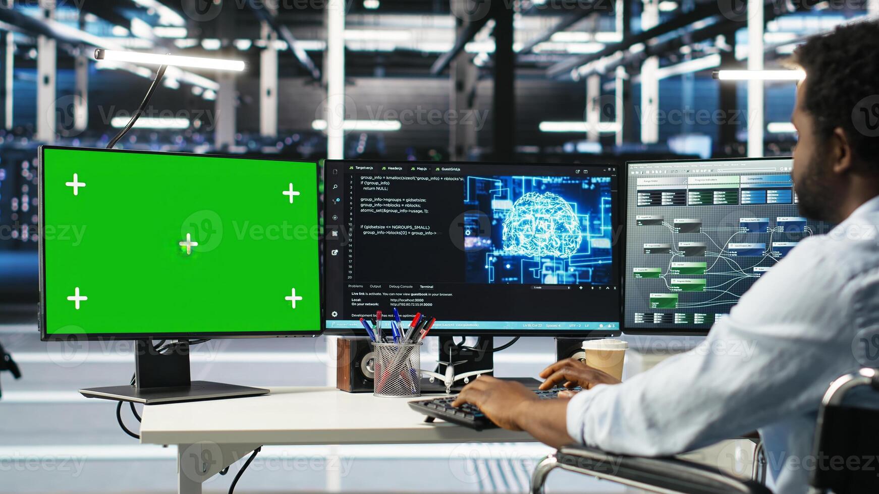 Engineer with paraplegia using AI deep learning algorithms on green screen PC to analyze datasets. Server room worker in wheelchair at chroma key PC using AI neural networks, camera B photo