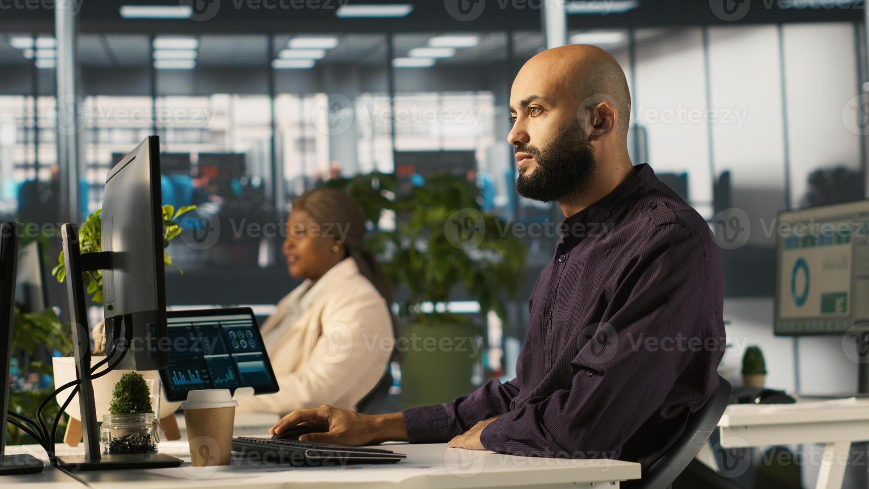 Arab man reviewing financial graphs, analyzing key performance indicators. Middle Eastern employee in workspace looking over data trends and strategic insights, camera A photo