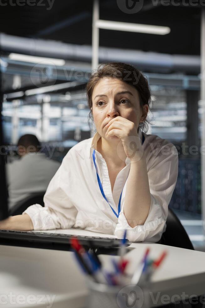 Computer scientist in data center running diagnostic scripts on computer, examining gear. Server room IT expert using PC to evaluate mainframes performance parameters, maintaining system stability photo
