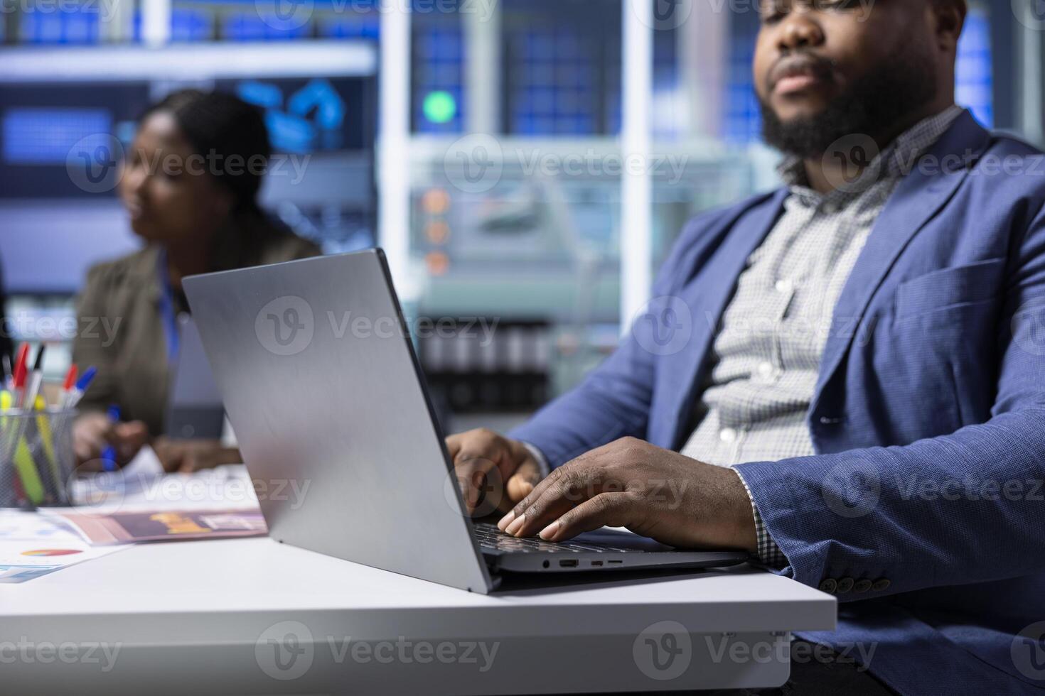 African american solar panels plant executive troubleshooting technical issues using notebook. Photovoltaics factory manager analyzing data using laptop, reviewing system health metrics, close up photo