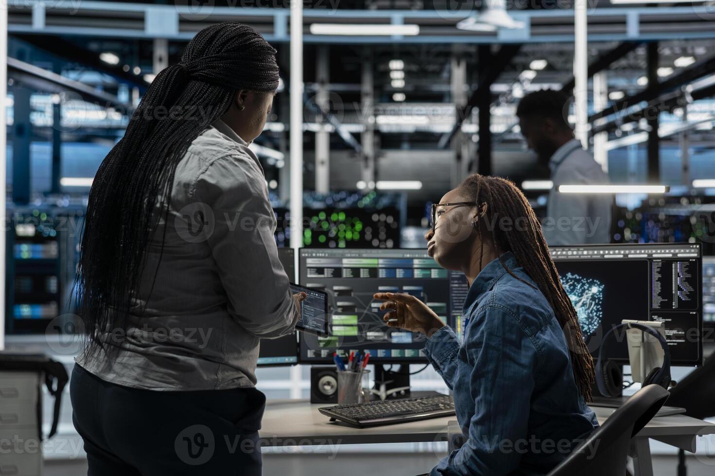 Data center team working together, using AI visualization tool to optimize equipment performance. Server farm coworkers doing brainstorming, using artificial intelligence analysis software photo