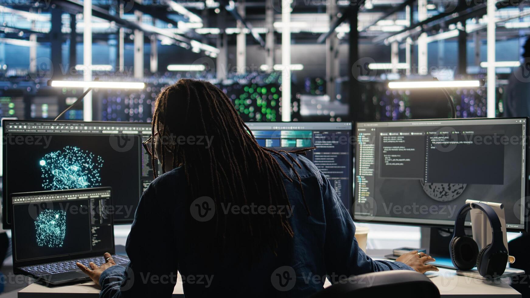 Data center administrator using machine learning algorithms to analyze large datasets. Server farm worker using AI neural networks on computer to recognize data patterns, camera A photo