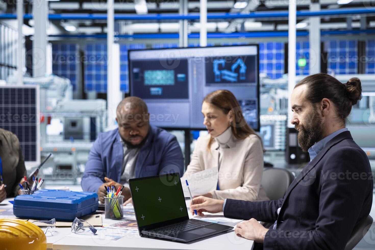 Factory researching team analyzing data, reviewing system health metrics with mockup laptop. Industrial plant management executives troubleshooting technical issues using chroma key notebook photo
