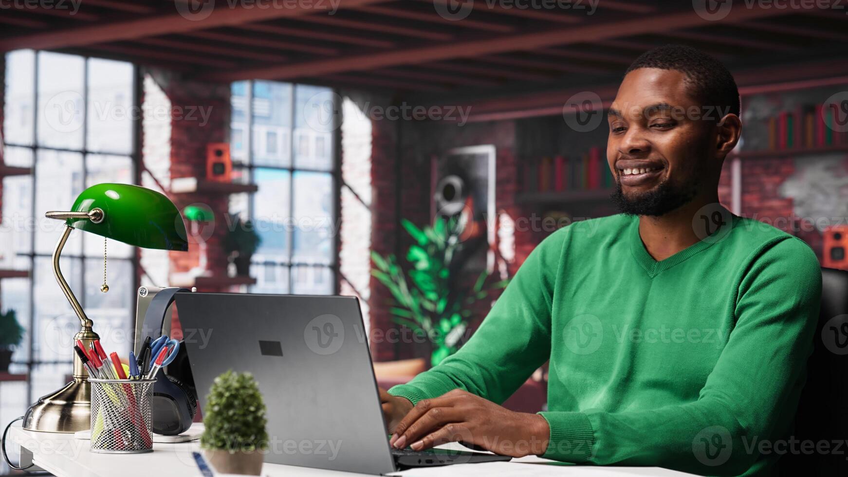Teleworker at home desk opening laptop to edit documents and solve daily tasks, updating reports and files. Young employee doing remote job and managing digital paperwork. Camera A. photo