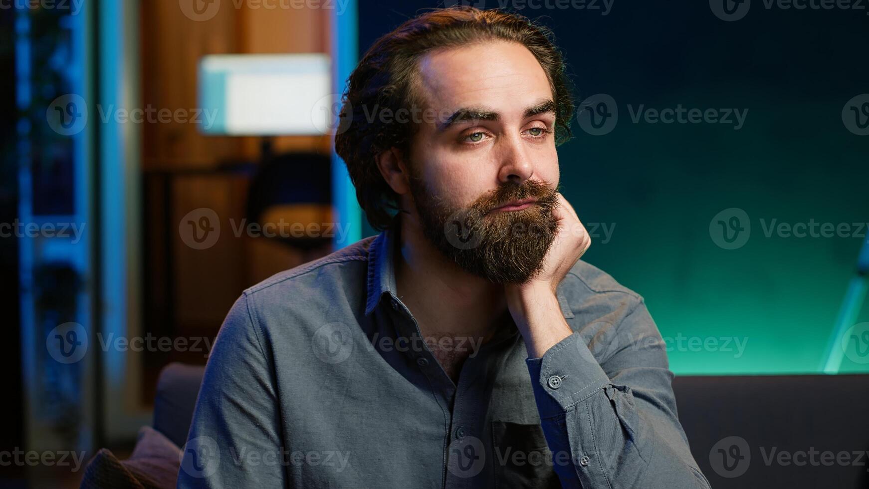 Man bored at home searching for TV series to binge on streaming services, procrastinating. Close up of person sitting on couch, flipping through channels using remote control, camera A photo