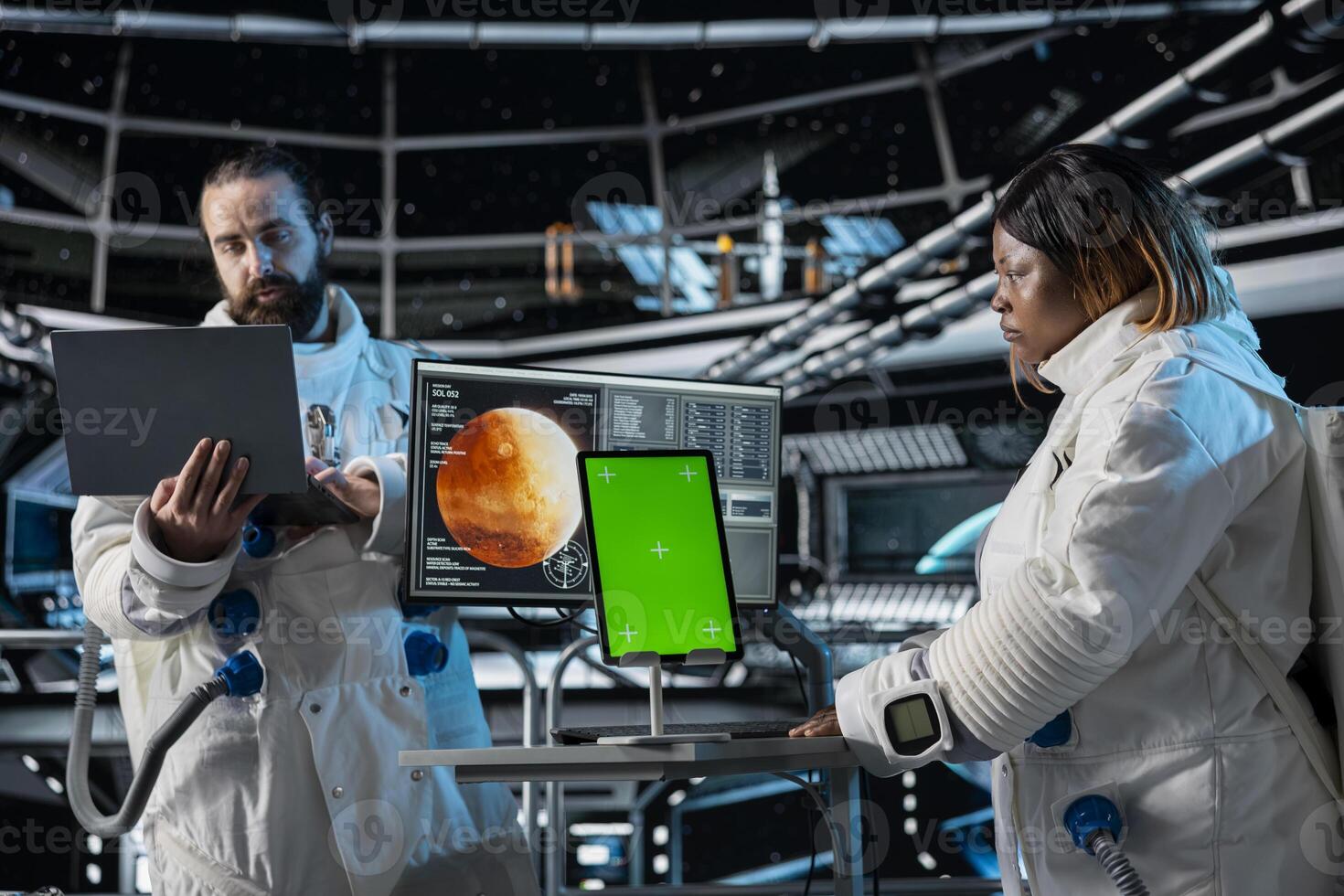 Orbital station coworkers analyzing Mars planetary data using green screen tablet. Team of astronauts in spaceship doing red planet surface research using chroma key device photo