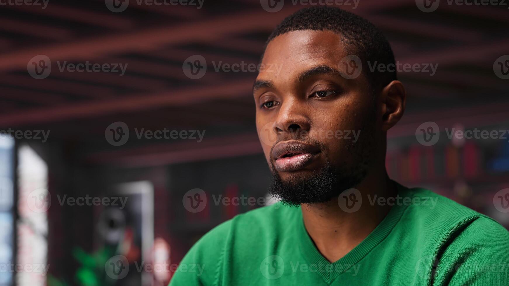 African american freelancer at home sitting at desk and typing on laptop keyboard, writing down ideas to solve daily assignments. Remote worker answering inquiries. Camera A. photo