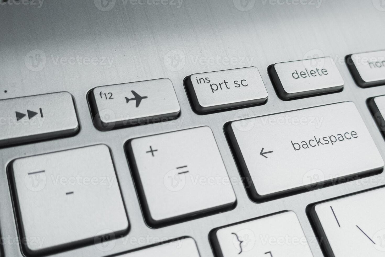 Closeup of Laptop Keyboard with Delete, Backspace, and Airplane Mode Keys photo